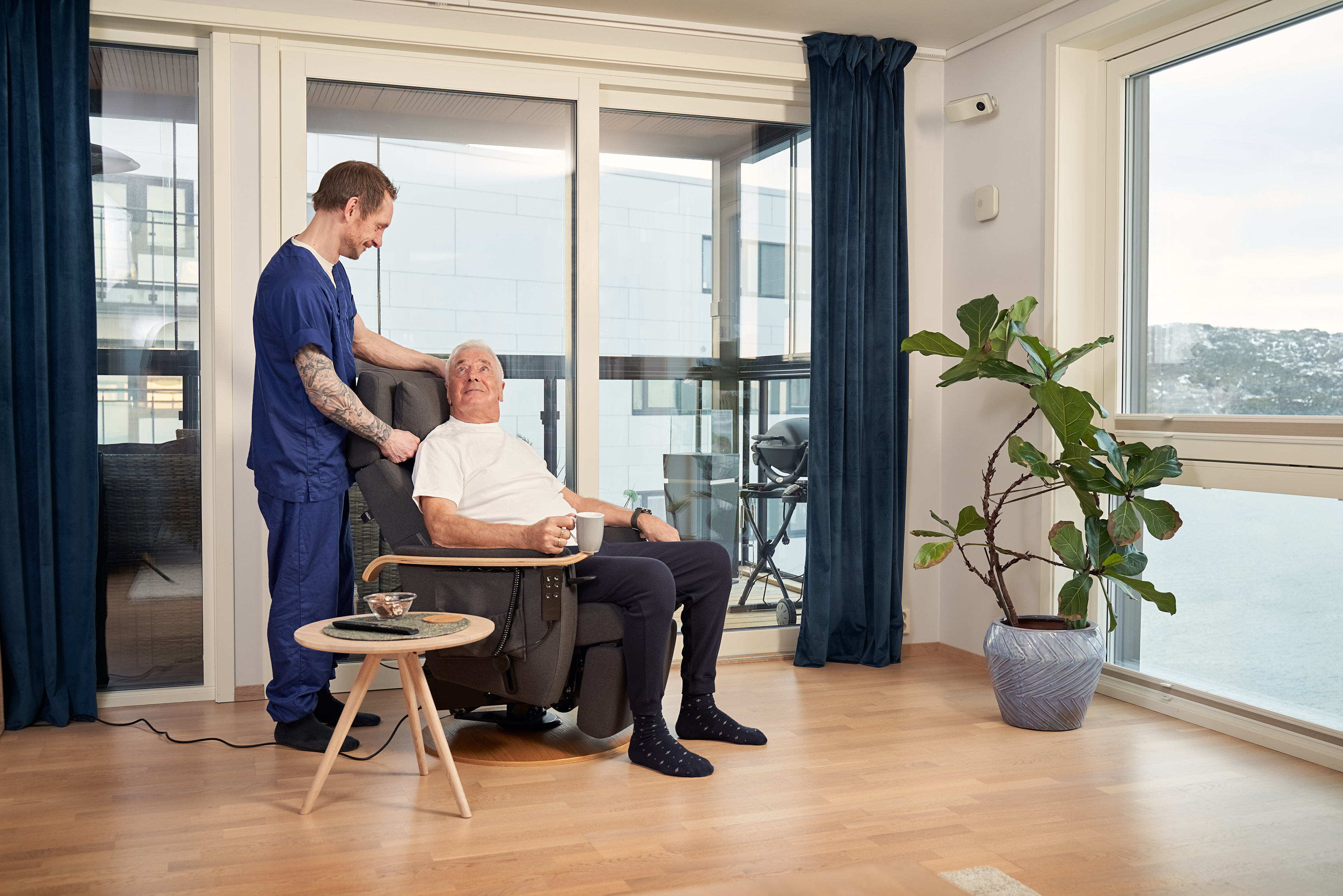 Helsearbeider og eldre mann i lys omsorgsbolig