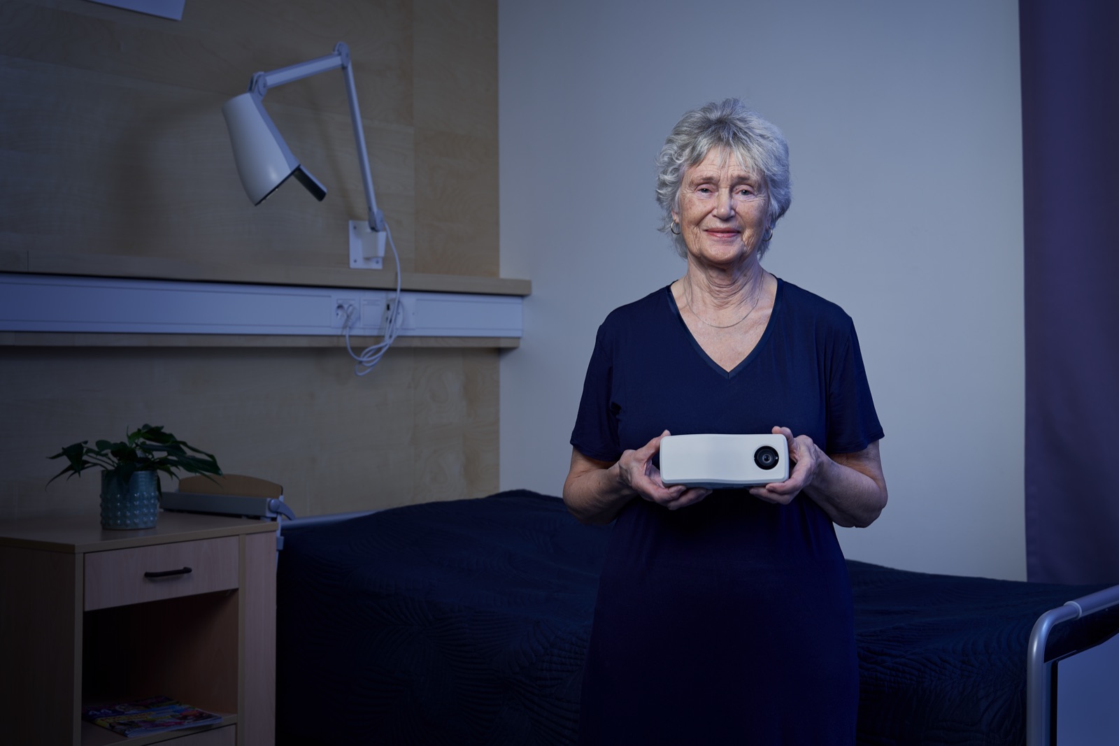 Eldre kvinne holder Nattugla-enheten